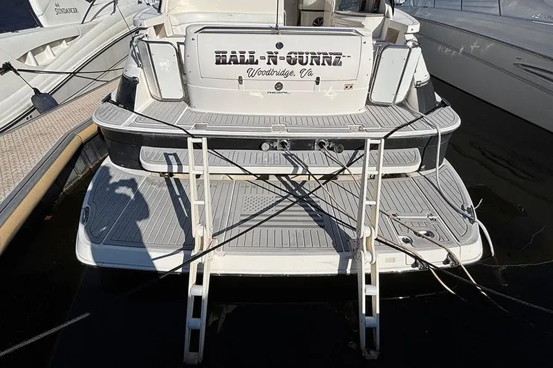 Slide: The Image of 2005 Regal Commodore 4260 yacht docked, featuring a swim platform and ladder. - 3