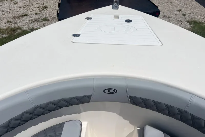Slide: The Image of 2026 Defiance Catalina 240 boat bow with cushioned seating and storage hatch. - 24
