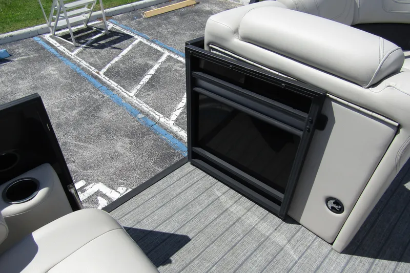 Slide: The Image of 2021 Starcraft SLS 1 boat interior with open storage compartment and cup holders. - 14