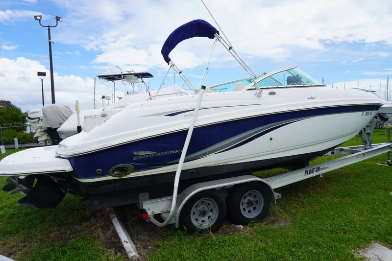 The Image of 2003 Chaparral 230 SSi boat on trailer, parked on grass under a blue sky. - 0