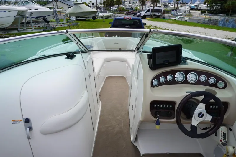 Slide: The Image of 2003 Chaparral 230 SSi boat interior with dashboard and steering wheel, docked at marina. - 12