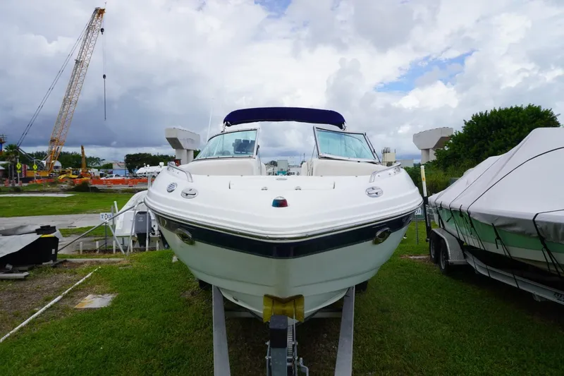 Slide: The Image of 2003 Chaparral 230 SSi boat on trailer, parked outdoors with construction crane in background. - 2