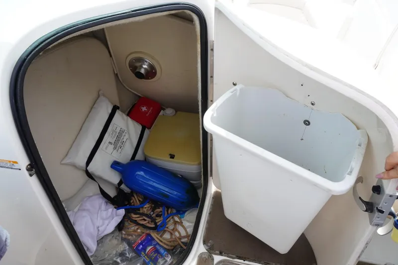 Slide: The Image of Storage compartment in a 2003 Chaparral 230 SSi boat with safety equipment and supplies. - 32