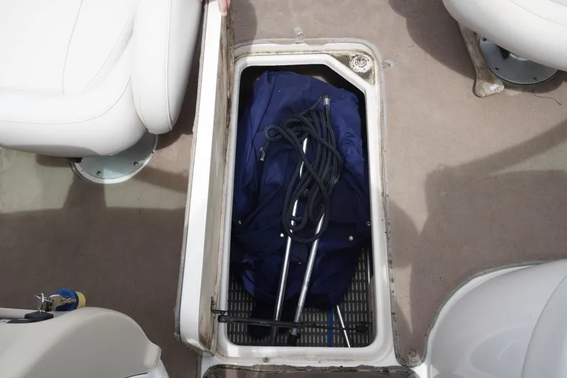 Slide: The Image of Storage compartment on a 2003 Chaparral 230 SSi boat with blue cover and rope. - 34