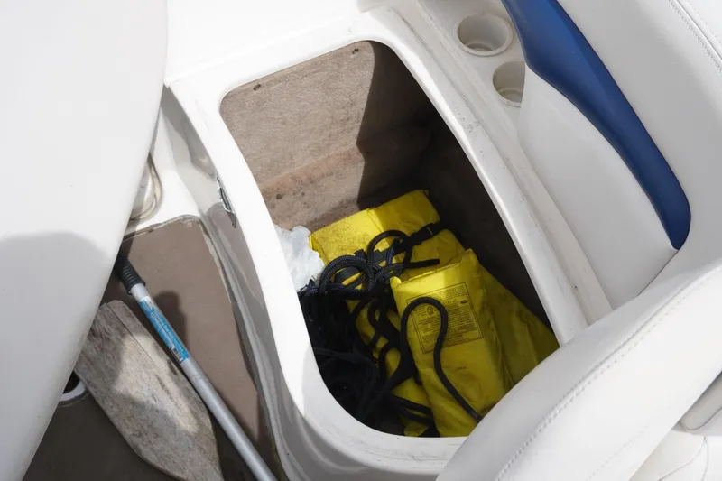 Slide: The Image of Storage compartment in 2003 Chaparral 230 SSi boat with yellow life jackets and rope. - 36