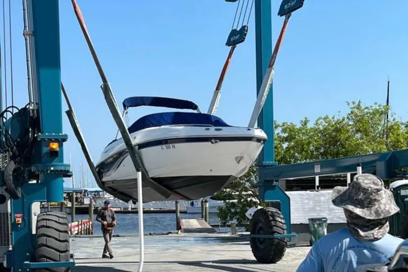 Slide: The Image of 2003 Chaparral 230 SSi boat being lifted by a crane at a marina. - 4