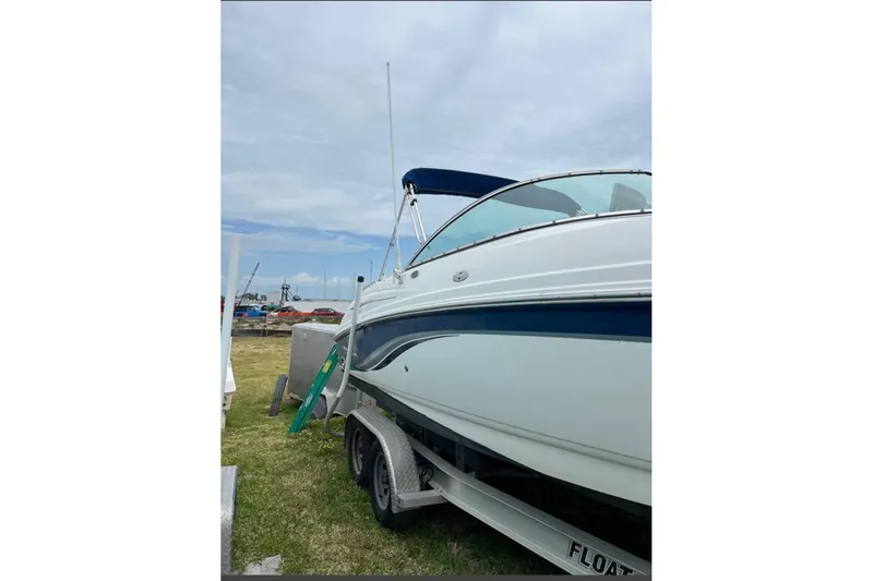 Slide: The Image of 2003 Chaparral 230 SSi boat on trailer, parked on grass under cloudy sky. - 5