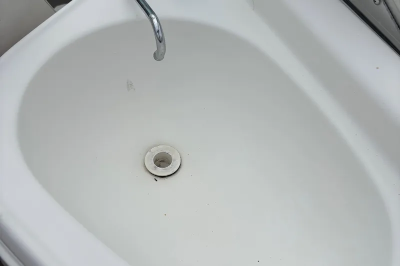 Slide: The Image of White sink with chrome faucet and drain, Chaparral 230 SSi, 2003 model. - 54