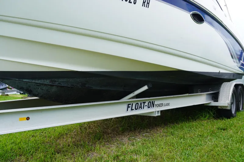 Slide: The Image of 2003 Chaparral 230 SSi boat on a Float-On trailer, parked on grass. - 59
