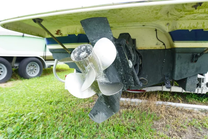 Slide: The Image of 2003 Chaparral 230 SSi boat propeller on grassy surface, close-up view. - 60