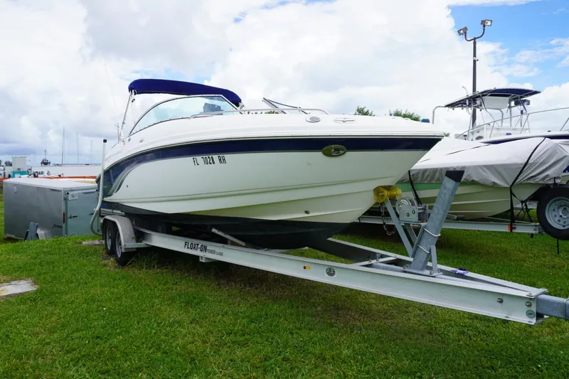 Slide: The Image of 2003 Chaparral 230 SSi boat on trailer, parked on grass under cloudy sky. - 8
