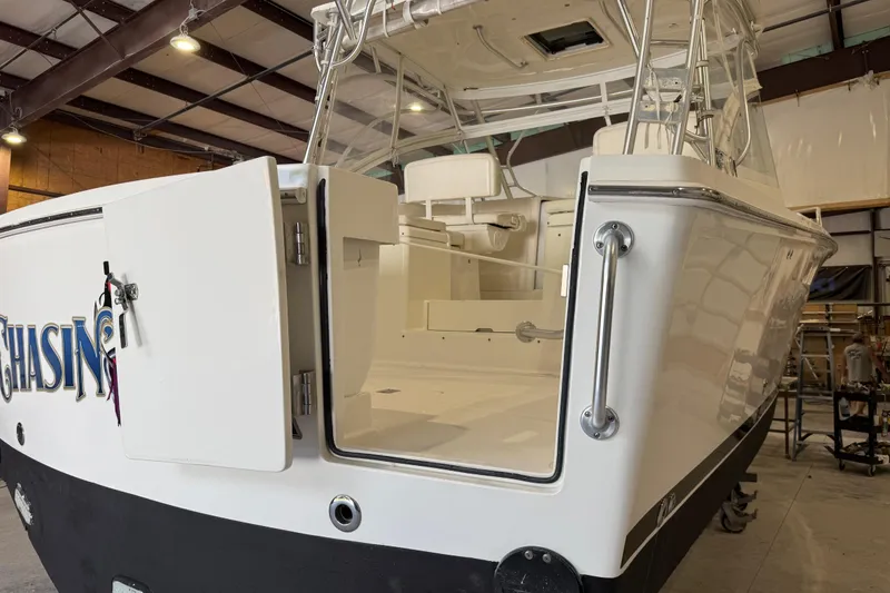 Slide: The Image of 2011 Luhrs 30 Open boat in a warehouse, showcasing open deck and sleek design. - 11