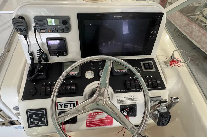 Slide: The Image of Control panel of a 2011 Luhrs 30 Open boat with steering wheel and navigation equipment. - 17