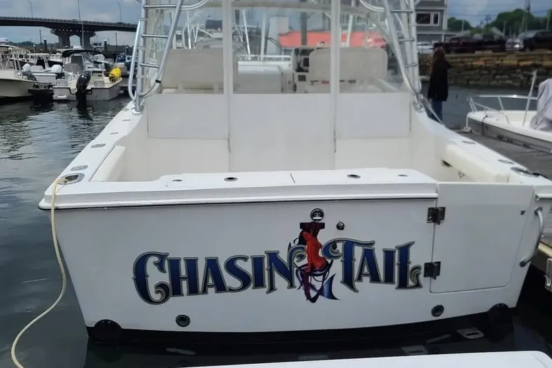 Slide: The Image of 2011 Luhrs 30 Open boat named "Chasin Tail" docked in a marina. - 2