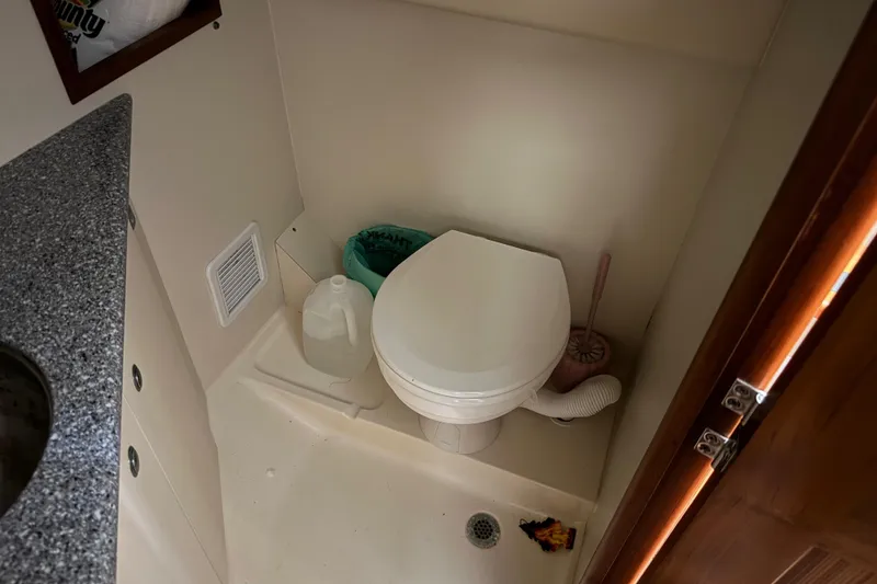 Slide: The Image of 2011 Luhrs 30 Open boat bathroom with toilet, sink, and storage. - 34