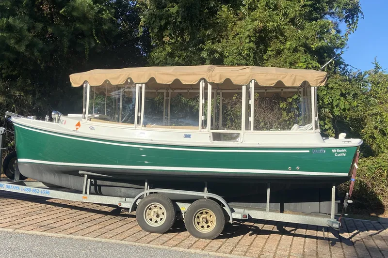 Slide: The Image of 2007 Duffy 22' Cuddy Cabin boat on trailer, green hull, beige canopy, parked outdoors. - 13