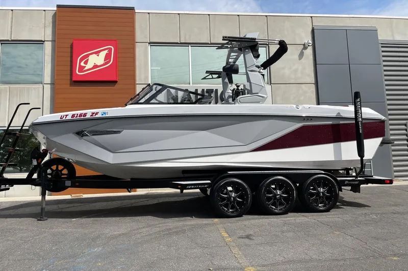 The Image of 2023 Nautique Super Air Nautique G23 boat on trailer, parked outside dealership. - 1