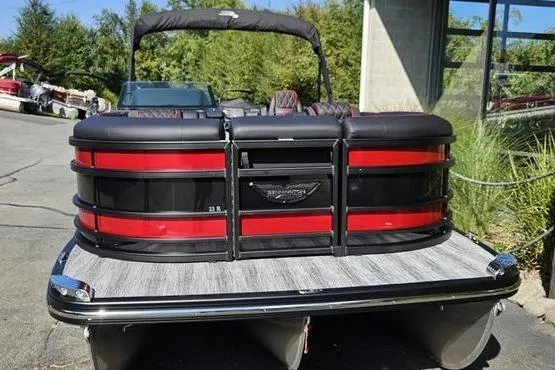 Slide: The Image of 2026 Bennington 23 RFB pontoon boat with red and black accents, docked outdoors. - 2