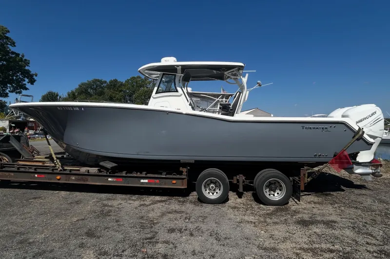 The Image of 2021 Tidewater 320 CC Adventure boat docked at marina under cloudy sky. - 0