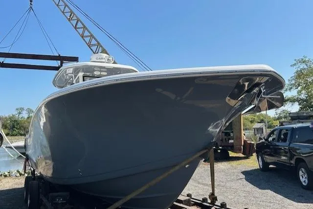 Slide: The Image of 2021 Tidewater 320 CC Adventure boat with twin Mercury 400 engines docked at marina. - 1