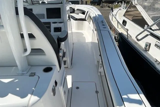 Slide: The Image of 2021 Tidewater 320 CC Adventure boat docked in a scenic waterfront setting. - 12