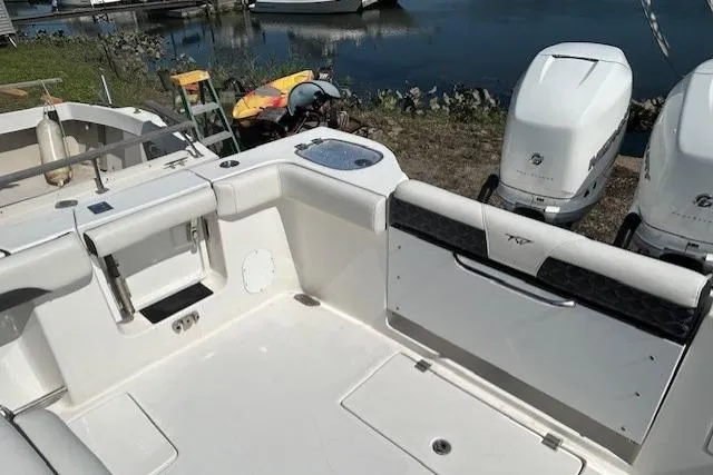 Slide: The Image of 2021 Tidewater 320 CC Adventure boat docked in a scenic waterfront area. - 15