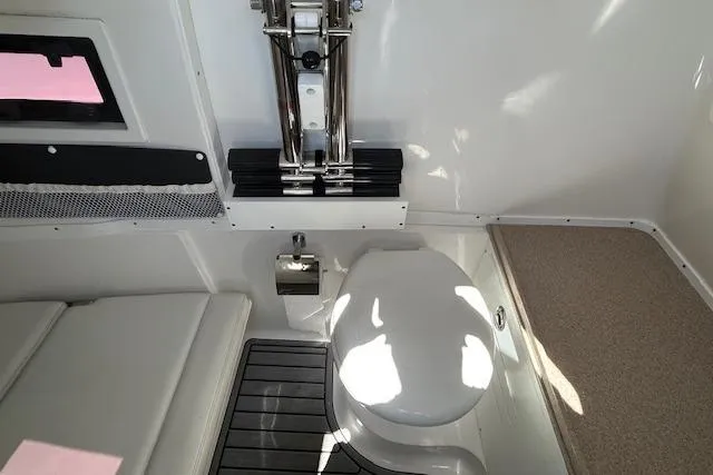 Slide: The Image of 2021 Tidewater 320 CC Adventure boat interior with cooler and seating area. - 18