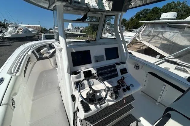 Slide: The Image of Covered 2021 Tidewater 320 CC Adventure boat on a lift by waterfront home. - 3