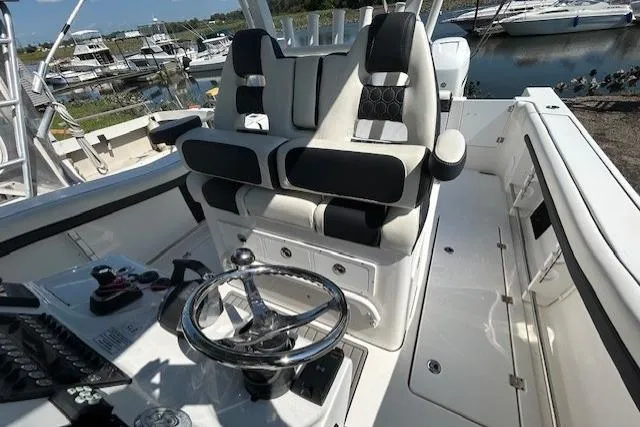 Slide: The Image of 2021 Tidewater 320 CC Adventure boat with Garmin radar, docked under a cloudy sky. - 4