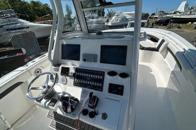 Slide: The Image of 2021 Tidewater 320 CC Adventure boat seats with black and white upholstery by the water. - 6