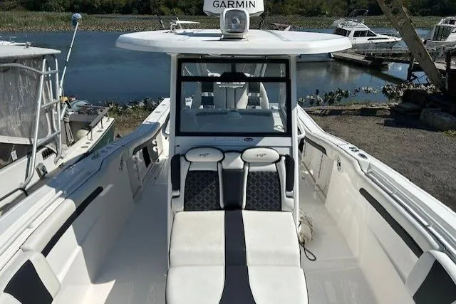 Slide: The Image of 2021 Tidewater 320 CC Adventure boat with blue interior lights at sunset. - 9