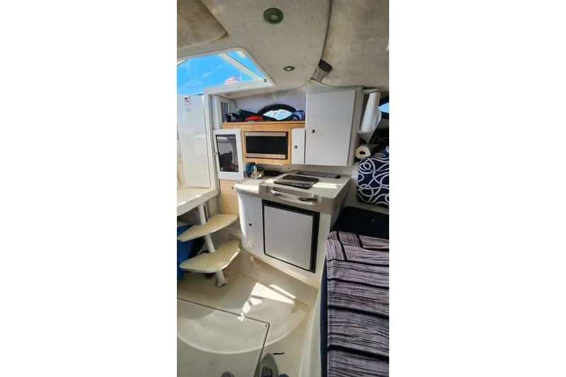Slide: The Image of Interior of 2001 Wellcraft 2900 Coastal WA boat, featuring compact kitchen and seating area. - 11
