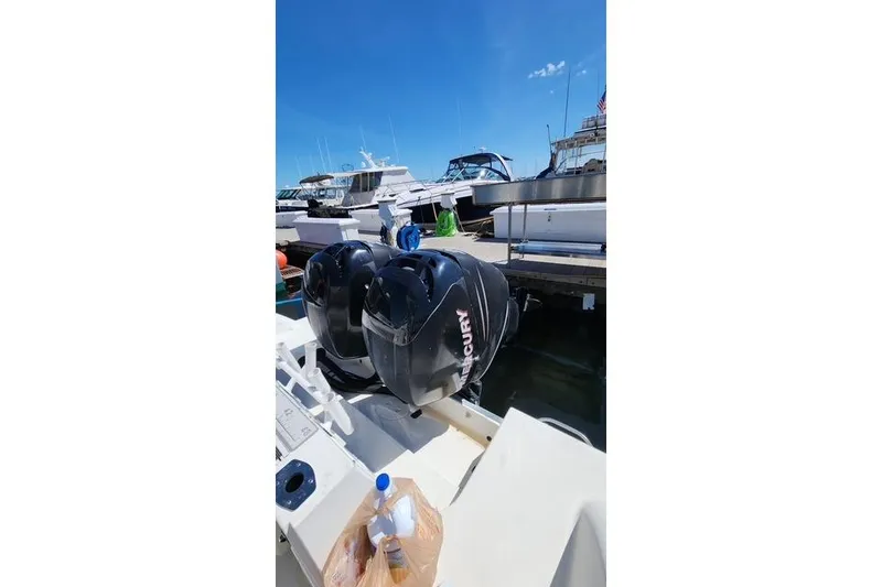 Slide: The Image of 2001 Wellcraft 2900 Coastal WA boat with dual Mercury outboard engines at a marina. - 21