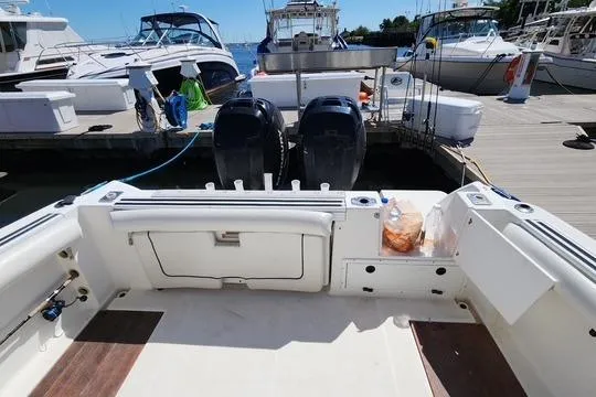 Slide: The Image of 2001 Wellcraft 2900 Coastal WA boat docked, featuring dual outboard motors and spacious deck area. - 9