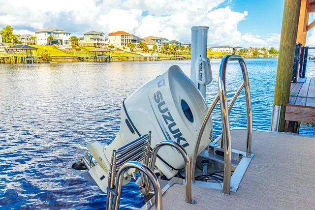 Slide: The Image of 2020 Avalon Catalina 2585 with Suzuki outboard motor docked by waterfront homes. - 11