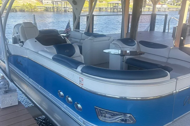 Slide: The Image of 2020 Avalon Catalina 2585 pontoon boat with luxurious seating and modern dashboard under a wooden canopy. - 3