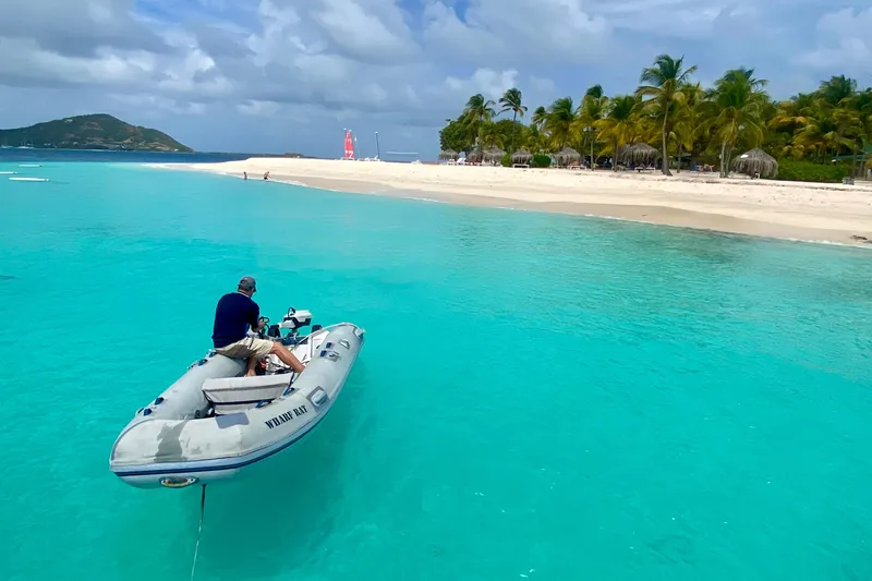 Slide: The Image of Man on inflatable boat approaching tropical beach with turquoise water, Vision 444, 2021. - 16