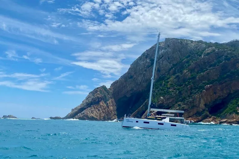 Slide: The Image of Sailboat Vision 444 (2021) cruising near rocky coastline under blue sky. - 6