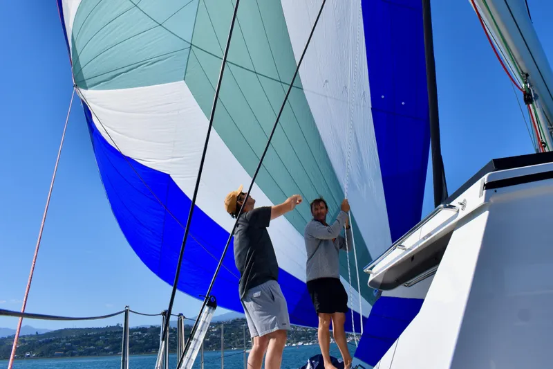 Slide: The Image of Two people adjusting a colorful sail on a Vision 444 yacht, 2021 model. - 8