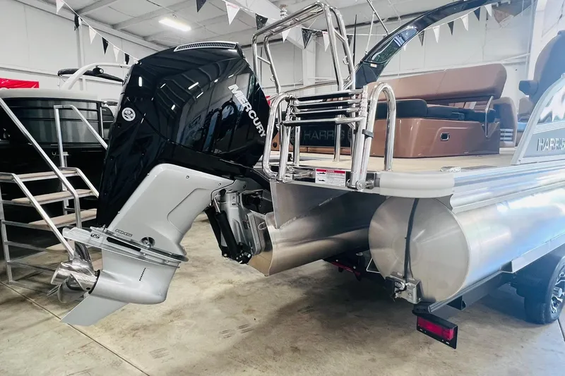 Slide: The Image of 2025 Harris 250 Grand Mariner V10 400 pontoon boat with Mercury outboard engine in showroom. - 2