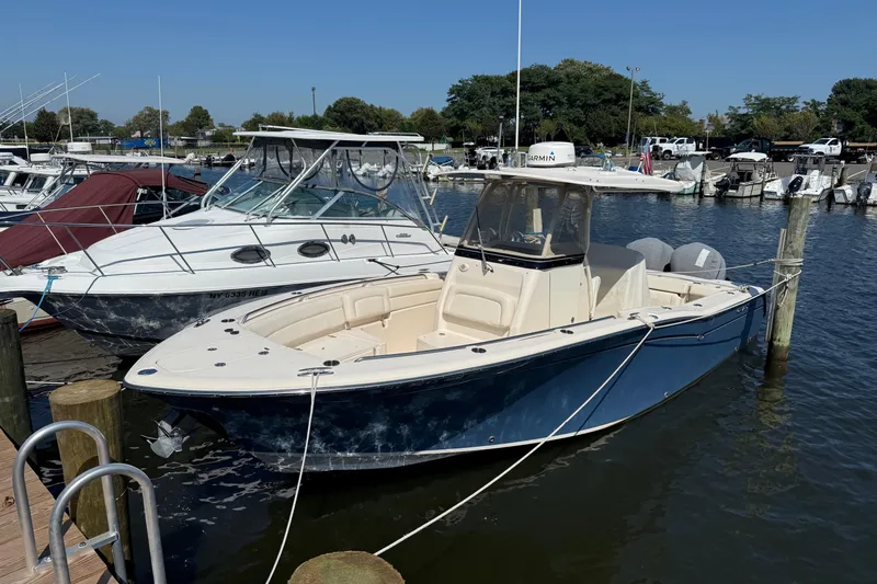 Slide: The Image of 2017 Grady-White Canyon 271 FS boat docked at marina, clear blue sky. - 0