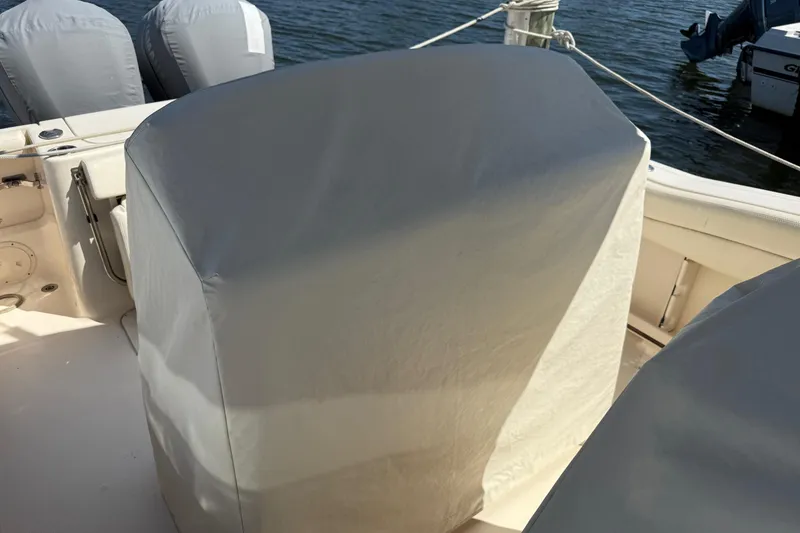 Slide: The Image of 2017 Grady-White Canyon 271 FS boat with covered seats and engines by the water. - 11