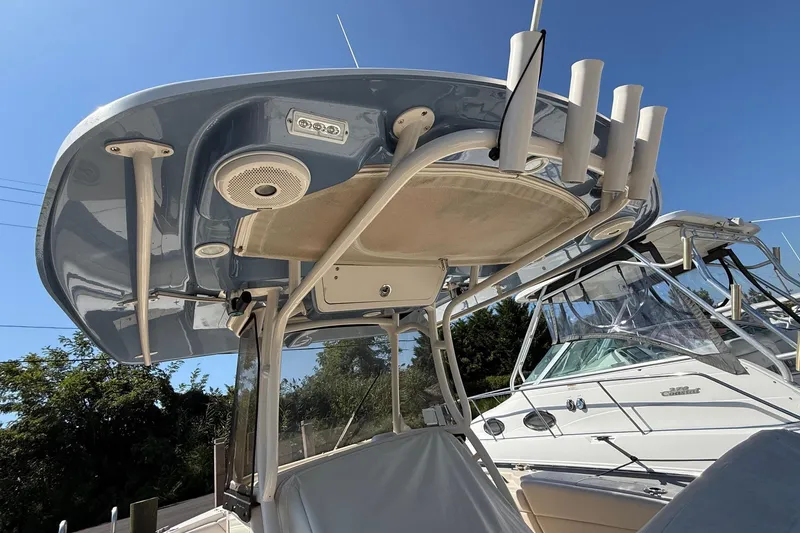 Slide: The Image of 2017 Grady-White Canyon 271 FS boat with T-top and rod holders under clear blue sky. - 15