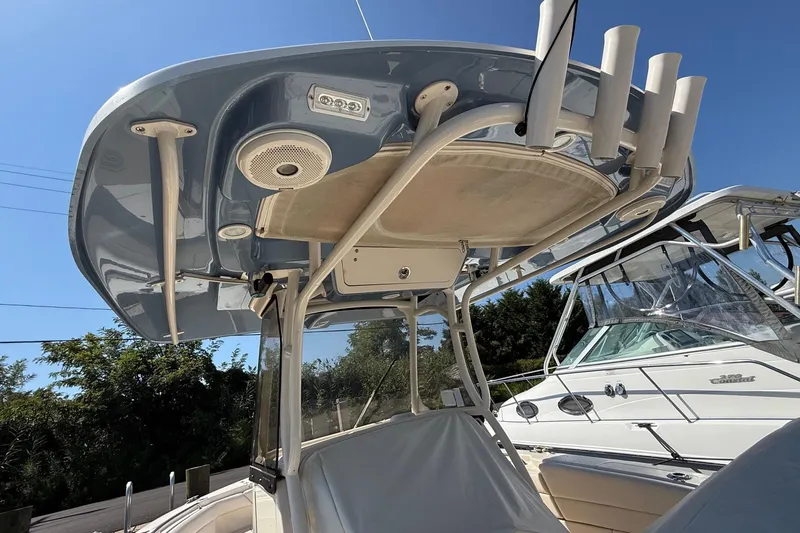 Slide: The Image of 2017 Grady-White Canyon 271 FS boat with T-top and rod holders, docked under clear sky. - 16