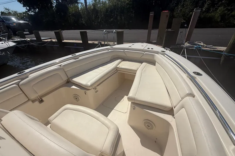 Slide: The Image of 2017 Grady-White Canyon 271 FS boat interior with beige seating at dock. - 2