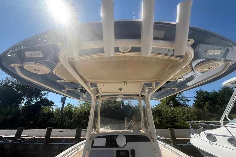 Slide: The Image of 2017 Grady-White Canyon 271 FS boat with T-top and console, under sunny sky. - 22