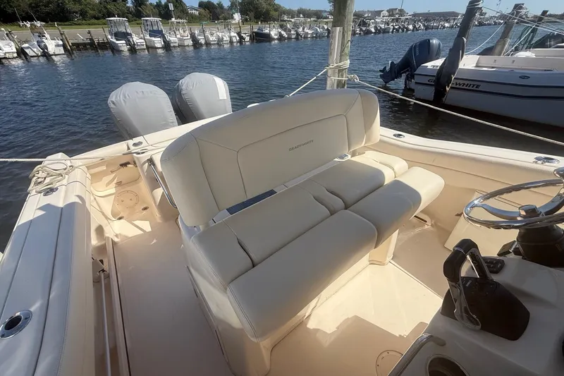 Slide: The Image of 2017 Grady-White Canyon 271 FS boat interior with seating and dual engines at a marina. - 27