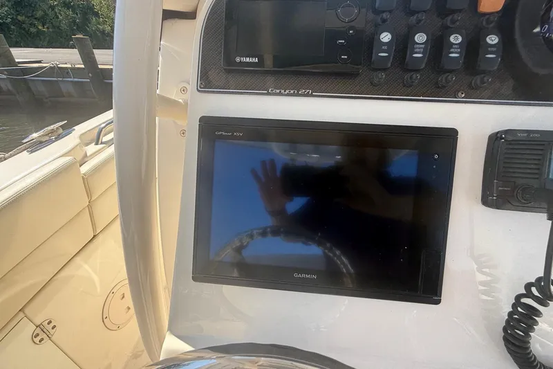 Slide: The Image of 2017 Grady-White Canyon 271 FS boat dashboard with Garmin GPS and Yamaha controls. - 29