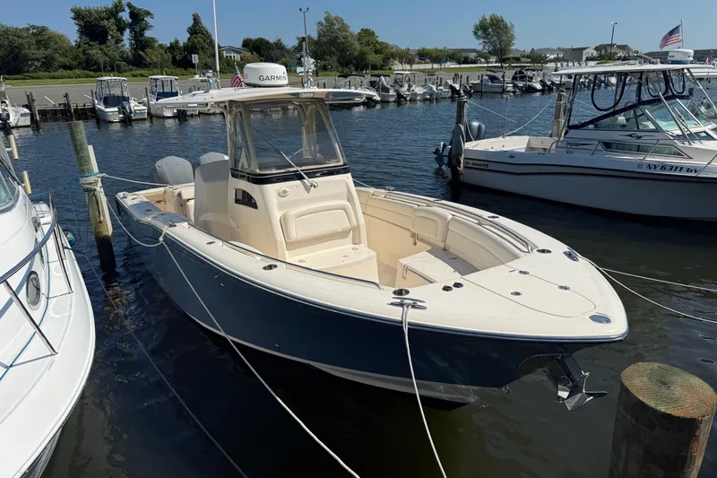Slide: The Image of 2017 Grady-White Canyon 271 FS boat docked in a marina, surrounded by other vessels. - 3