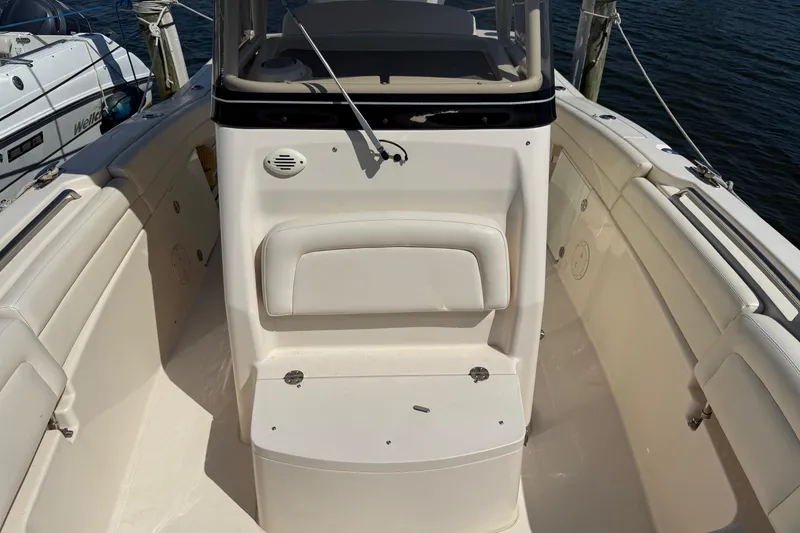 Slide: The Image of 2017 Grady-White Canyon 271 FS boat interior with seating and storage, docked by the water. - 6
